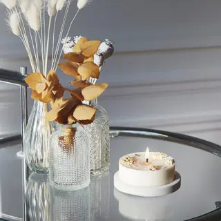 Assortiment de vases et bougie posés sur une table.